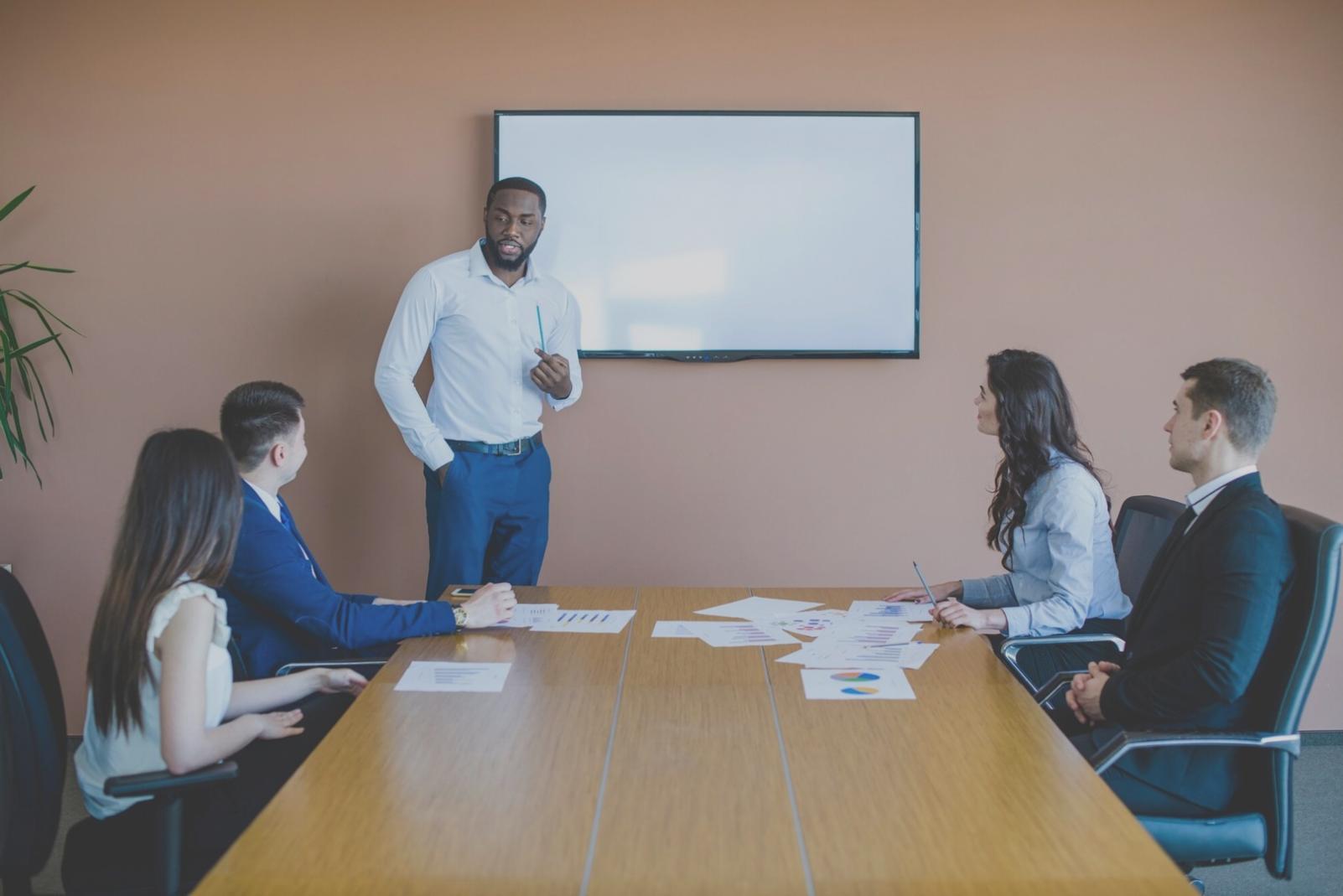 Teammeeting in modernem Konferenzraum mit digitalen Präsentationstools